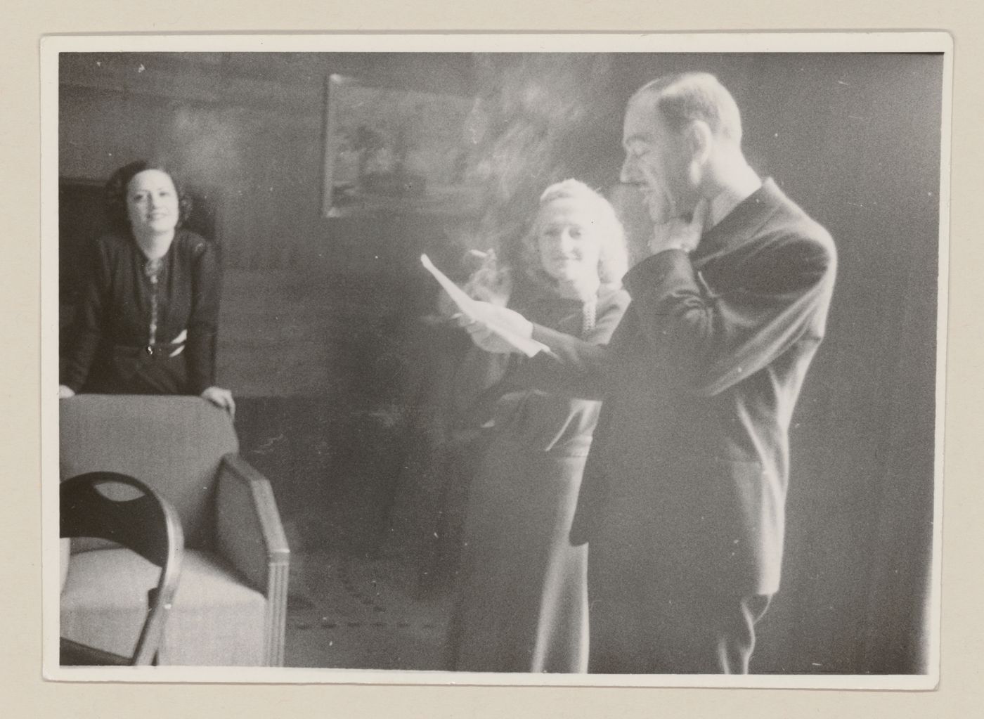 Portrait de Clorinthe et Cécile Perron écoutant pendant qu'un invité lit un texte à haute voix à la maison d'Ernest Cormier