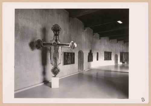 Interior view of a gallery showing a freestanding painted crucifix and paintings, Museo di Castelvecchio, Verona, Italy