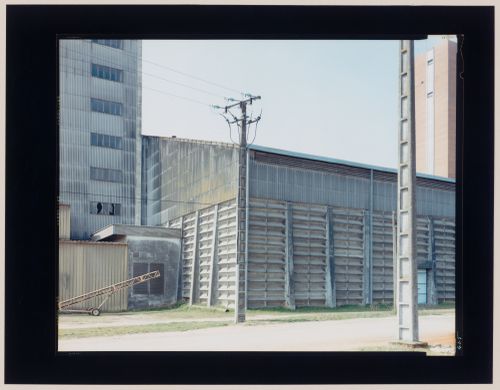 View of agricultural buildings and utility poles, La Villedieu, near Niort, France (from the series "In between cities")