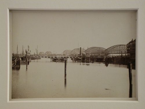 View of a harbor, lake, or river with a very long metal bridge in the distance, England ?