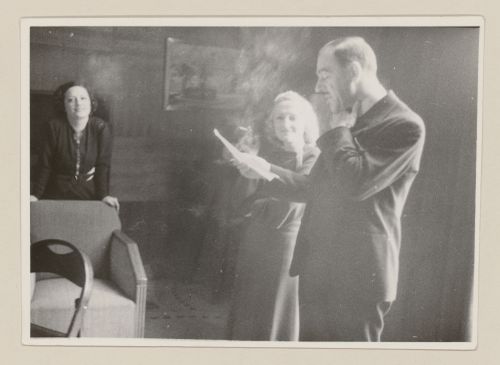 Portrait de Clorinthe et Cécile Perron écoutant pendant qu'un invité lit un texte à haute voix à la maison d'Ernest Cormier