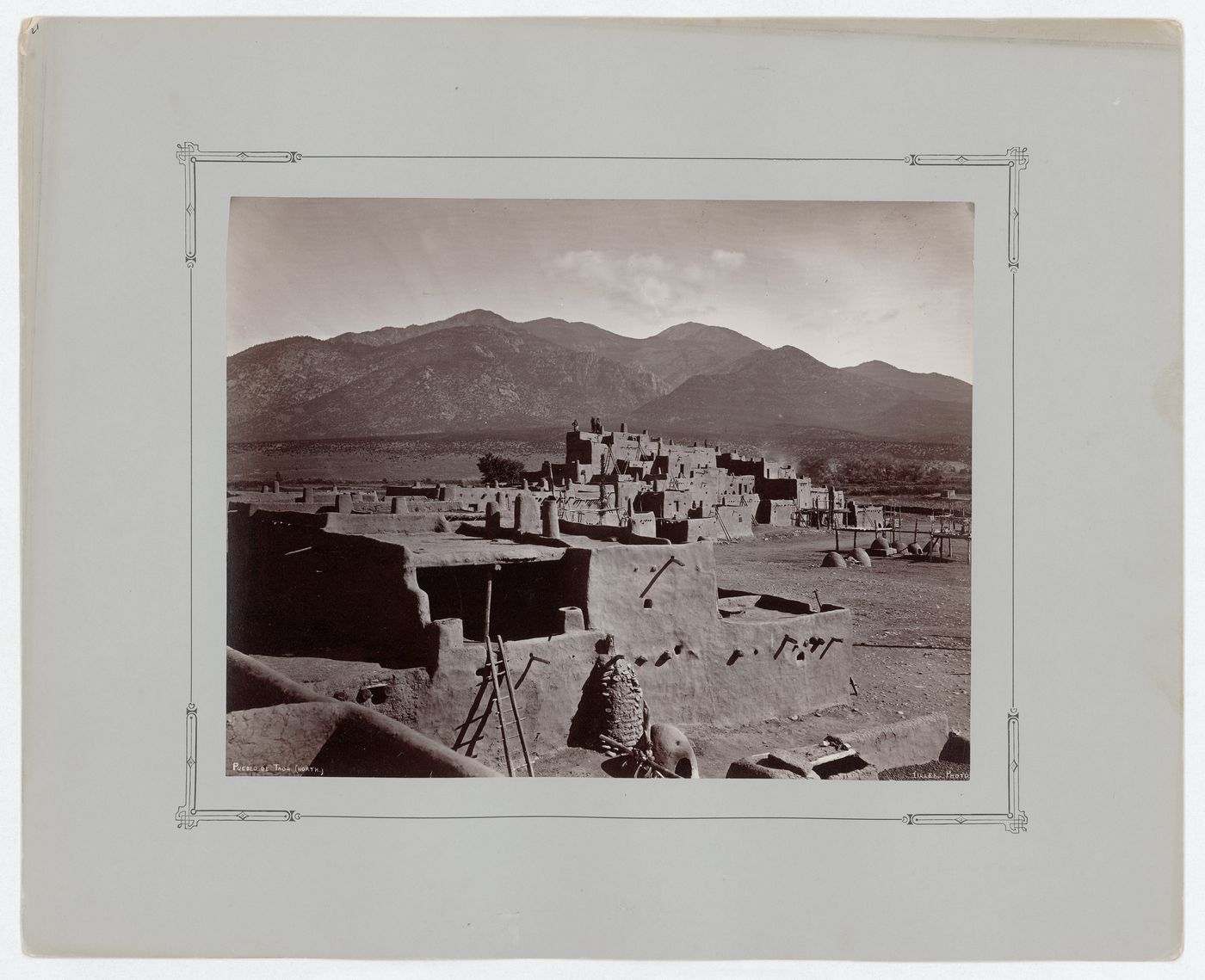 View of multi-storied houses on the north side of Taos Pueblo with Taos Mountains in the background, New Mexico, United States