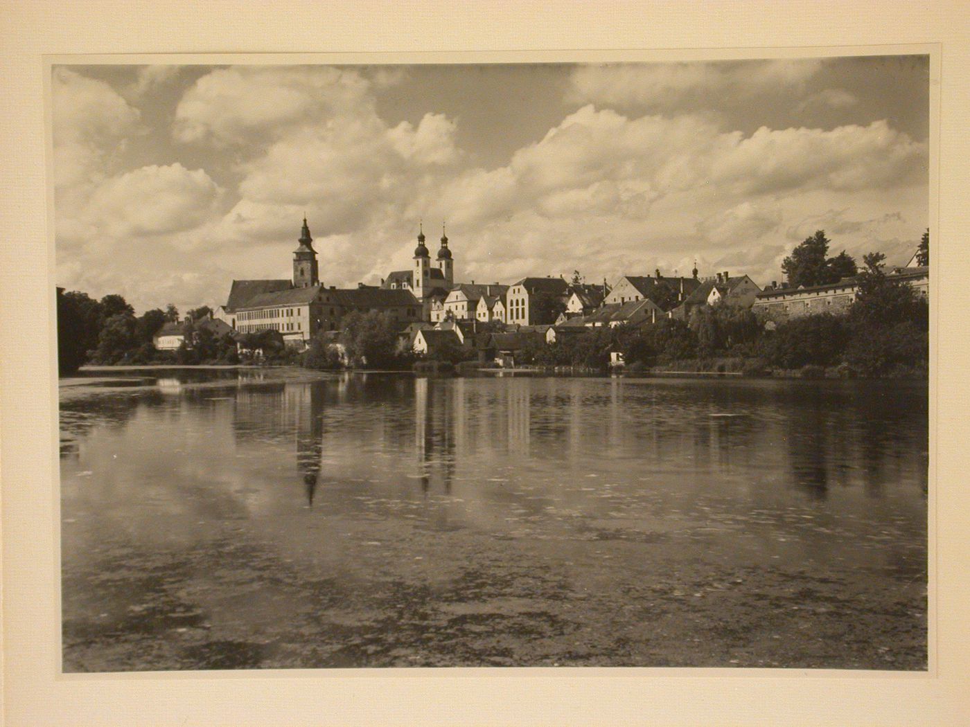 View across Ulický Pond towards Telc showing St. James Church and the Church of Jesus' Name, Czechoslovakia (now Czech Republic)