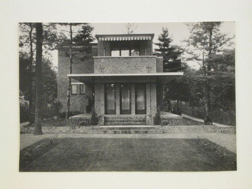 View of a villa showing three doors, balcony and windows, surrounded by a lawn, garden and trees, Belgium