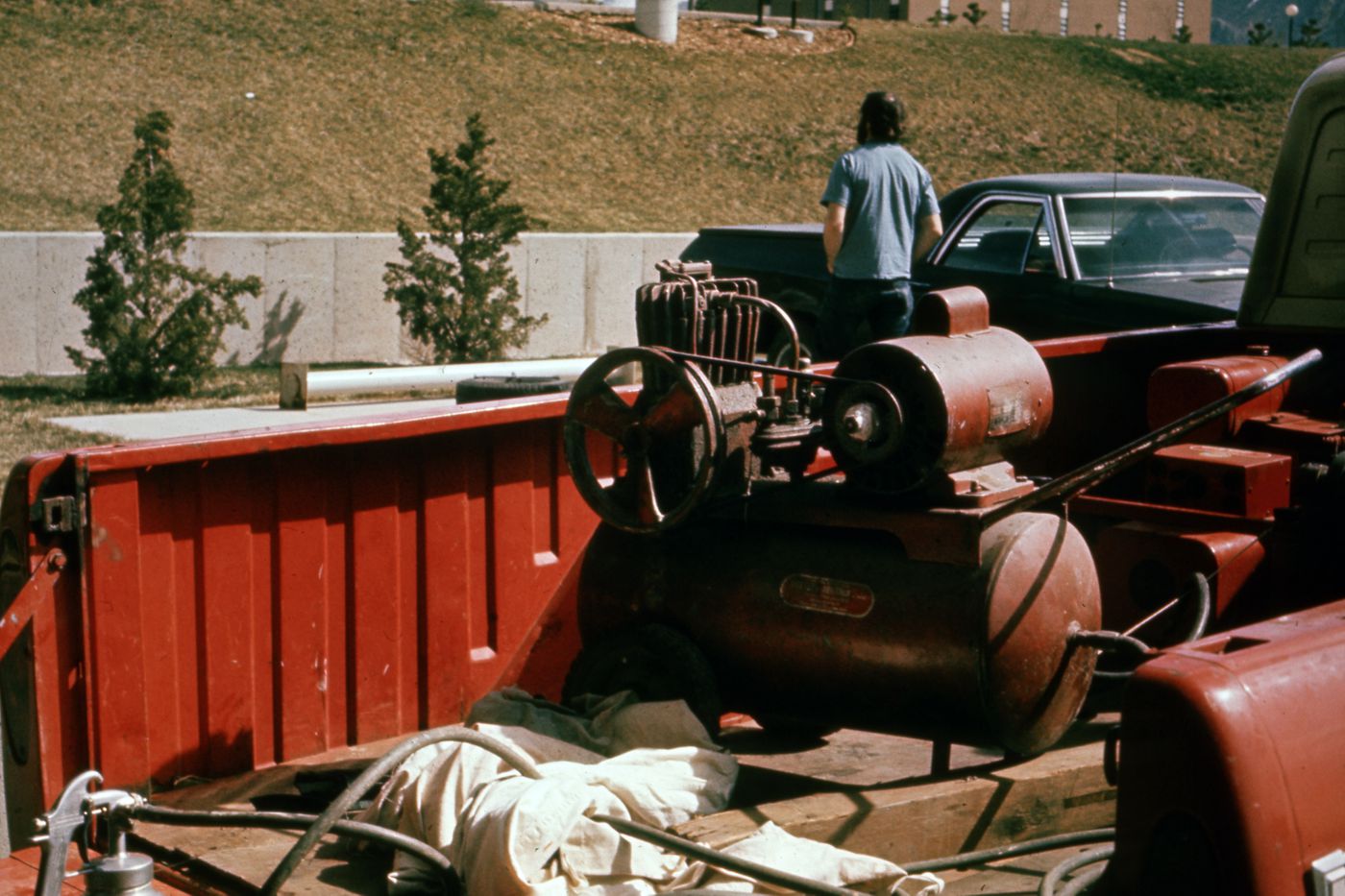 Photograph of paint sprayer and compressor in the back of a truck for Red Line