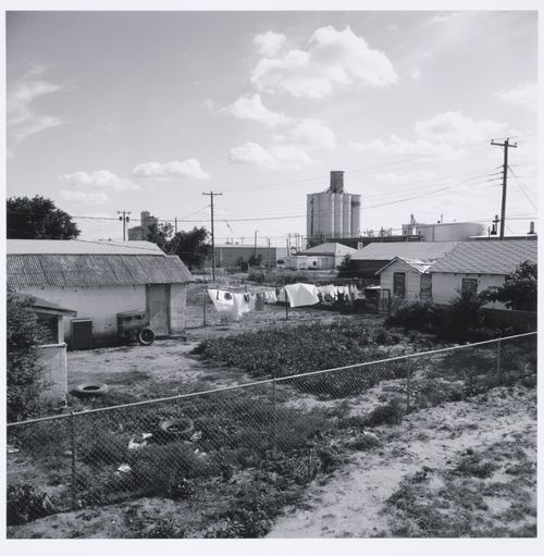 Clothesline in backyard, grain elevators in distance, Tulia, Texas