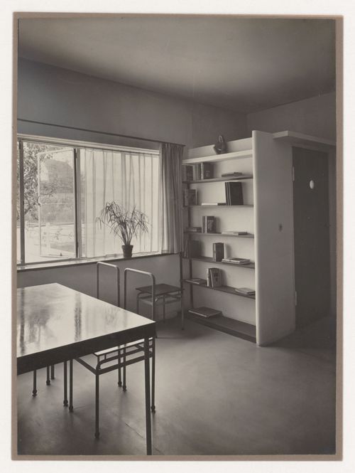 Interior view of the living room of House 8 showing a table, chairs and built-in bookshelf, Weissenhofsiedlung, Stuttgart, Germany