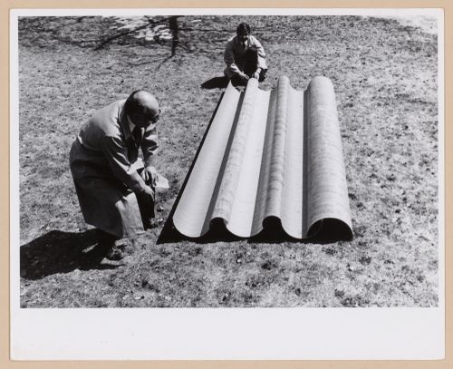Two member of Minimum Cost Housing Group and a piece of the roofing of Ecol House