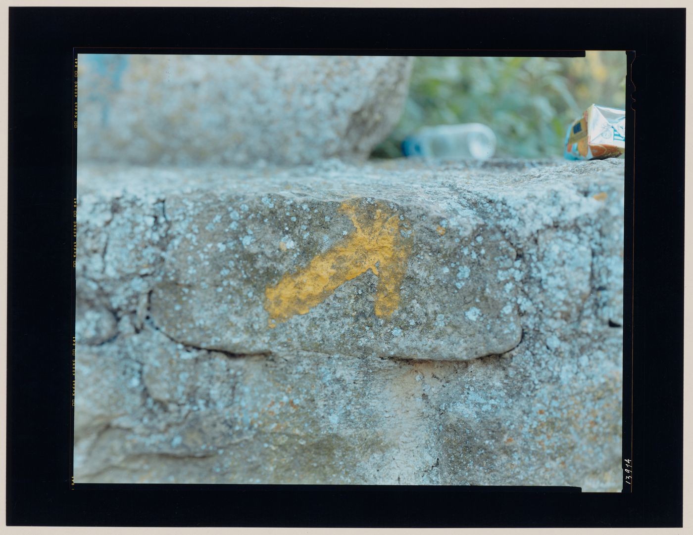 Close-up view of a stone wall bearing a painted arrow showing rubbish, Puente la Reina, Spain (from the series "In between cities")