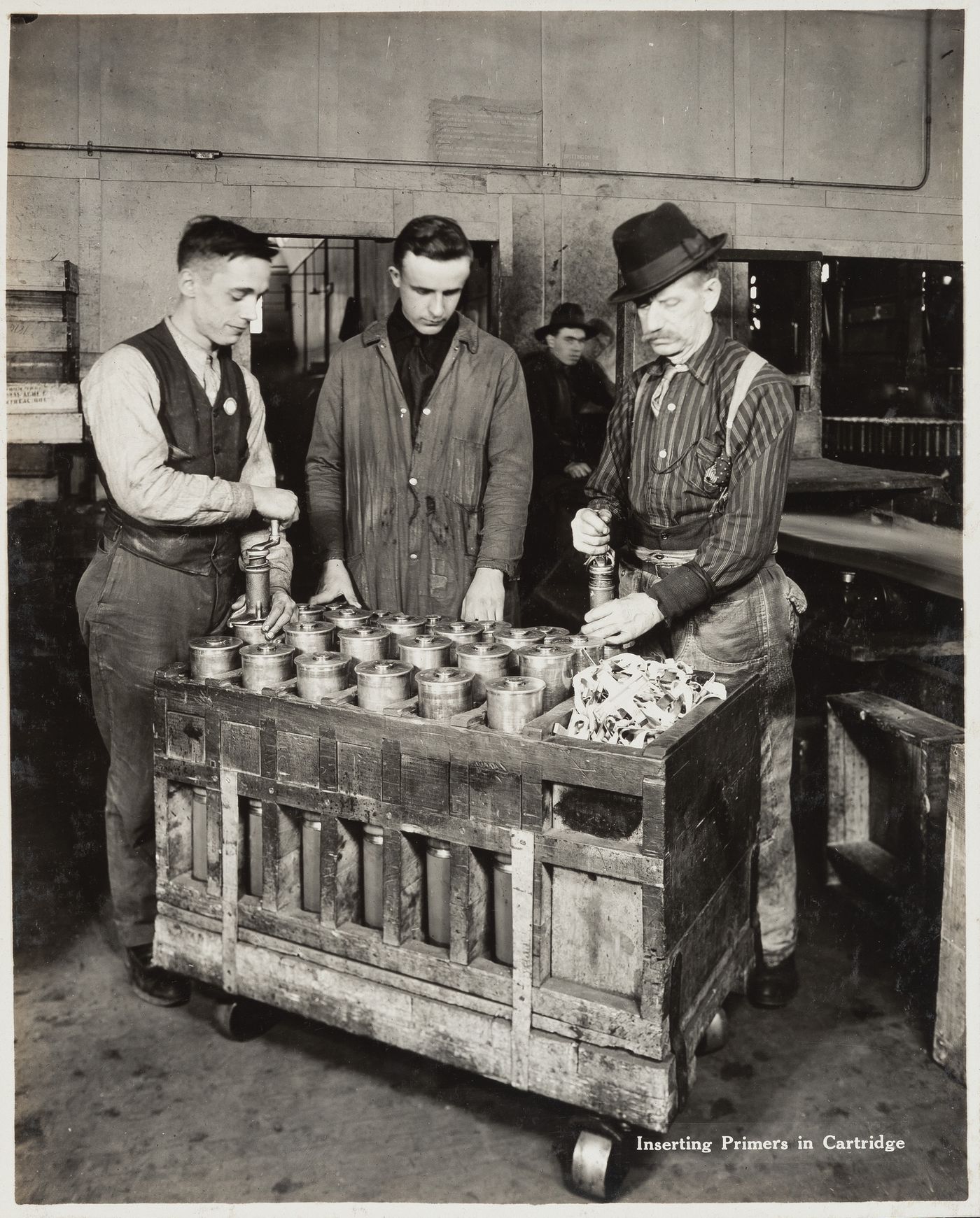 Interior view of workers inserting primers in cartridge at the Energite Explosives Plant No. 3, the Shell Loading Plant, Renfrew, Ontario, Canada