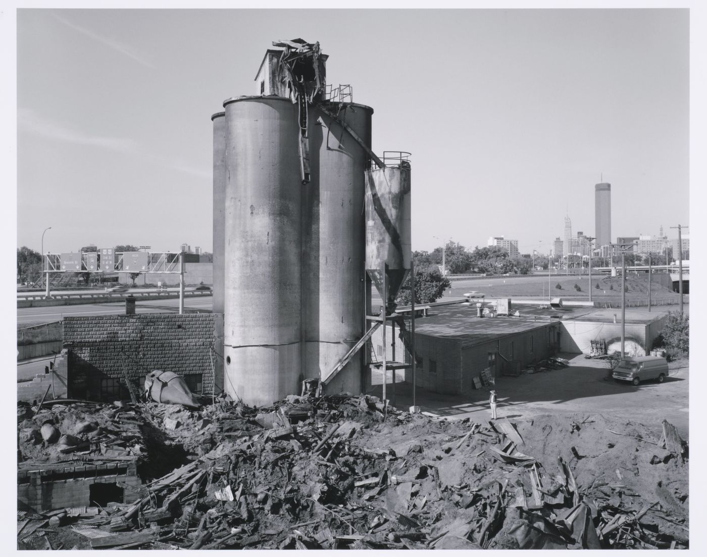 Man looking at pile of rubble next to standing elevators, Minneapolis, Minnesota