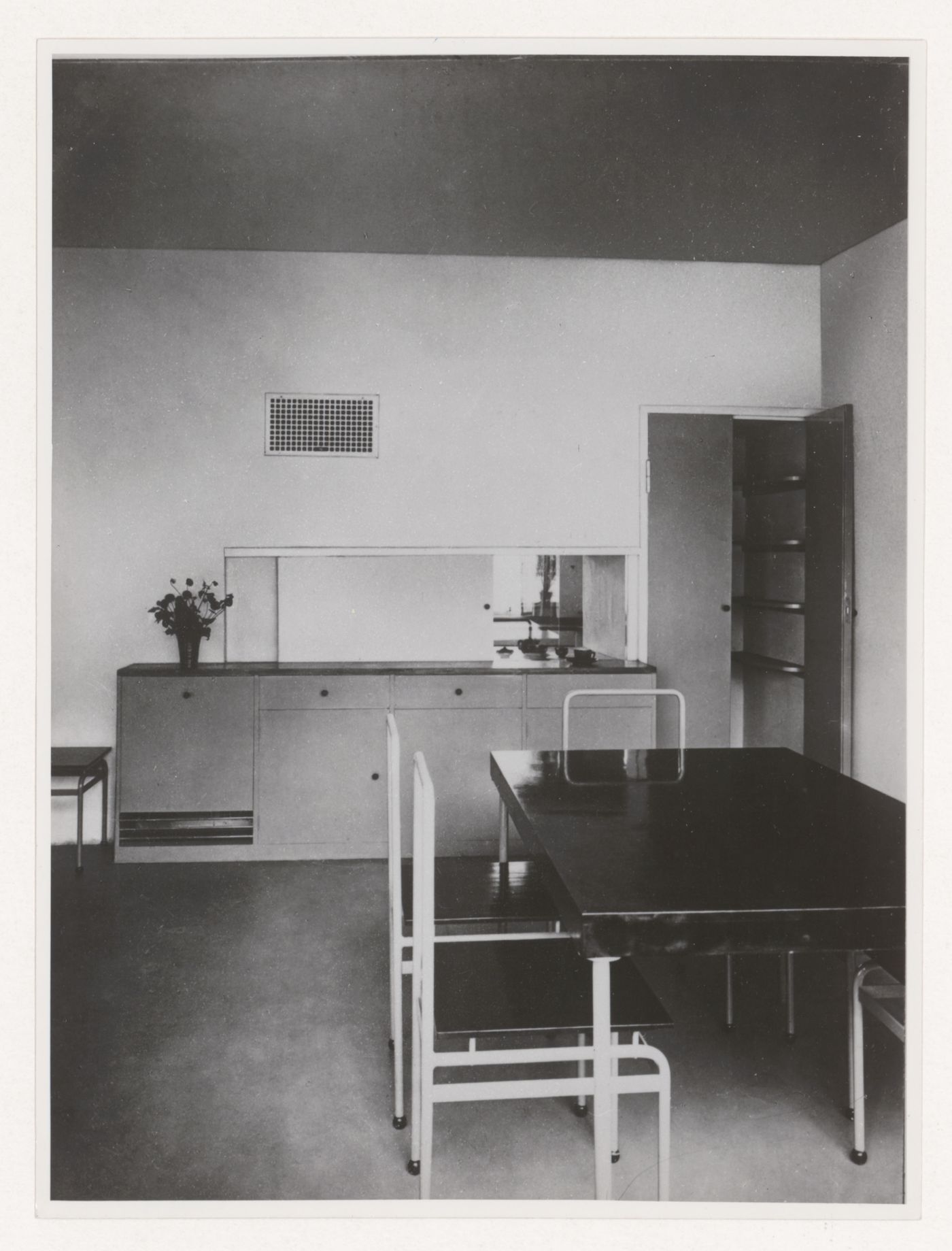 Interior view of the dining room of House 8 showing a table, chairs, buffet and serving window open to the kitchen, Weissenhofsiedlung, Stuttgart, Germany