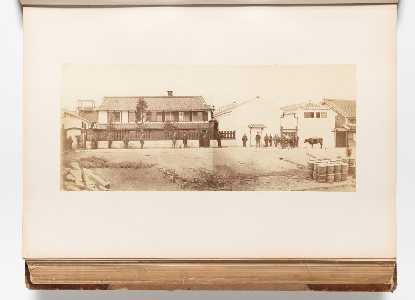 Panorama of the premises of Walsh & Co. showing buildings and men, possibly including John Walsh, Kobe, Japan