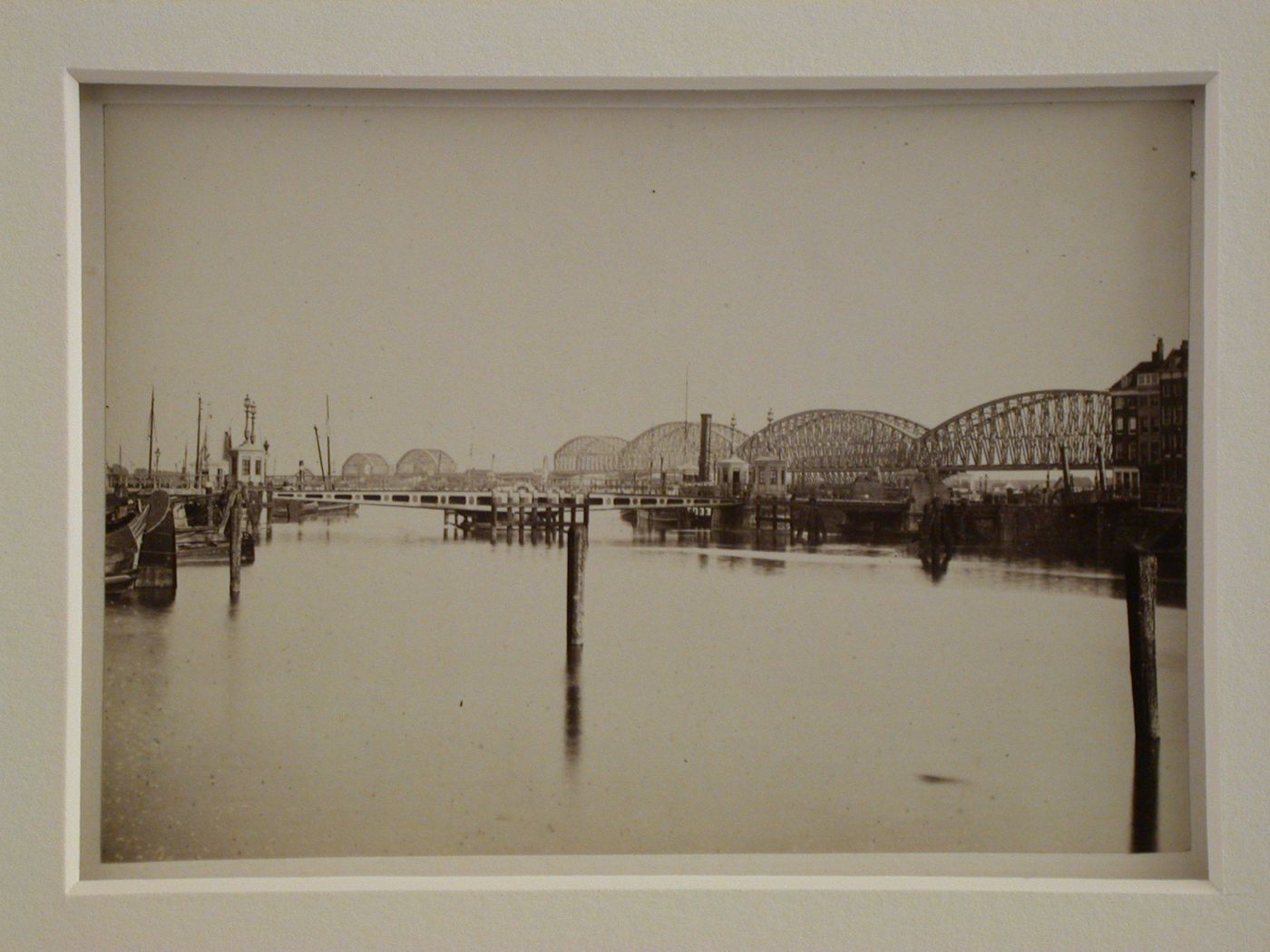 View of a harbor, lake, or river with a very long metal bridge in the distance, England ?