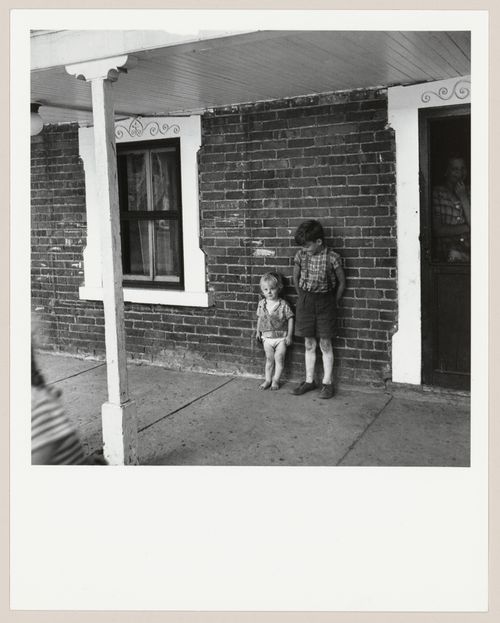 Portrait d'Eugène Arsenault et de son frère ainé, devant le portique de leur maison,  L'Islet-sur-Mer, Québec