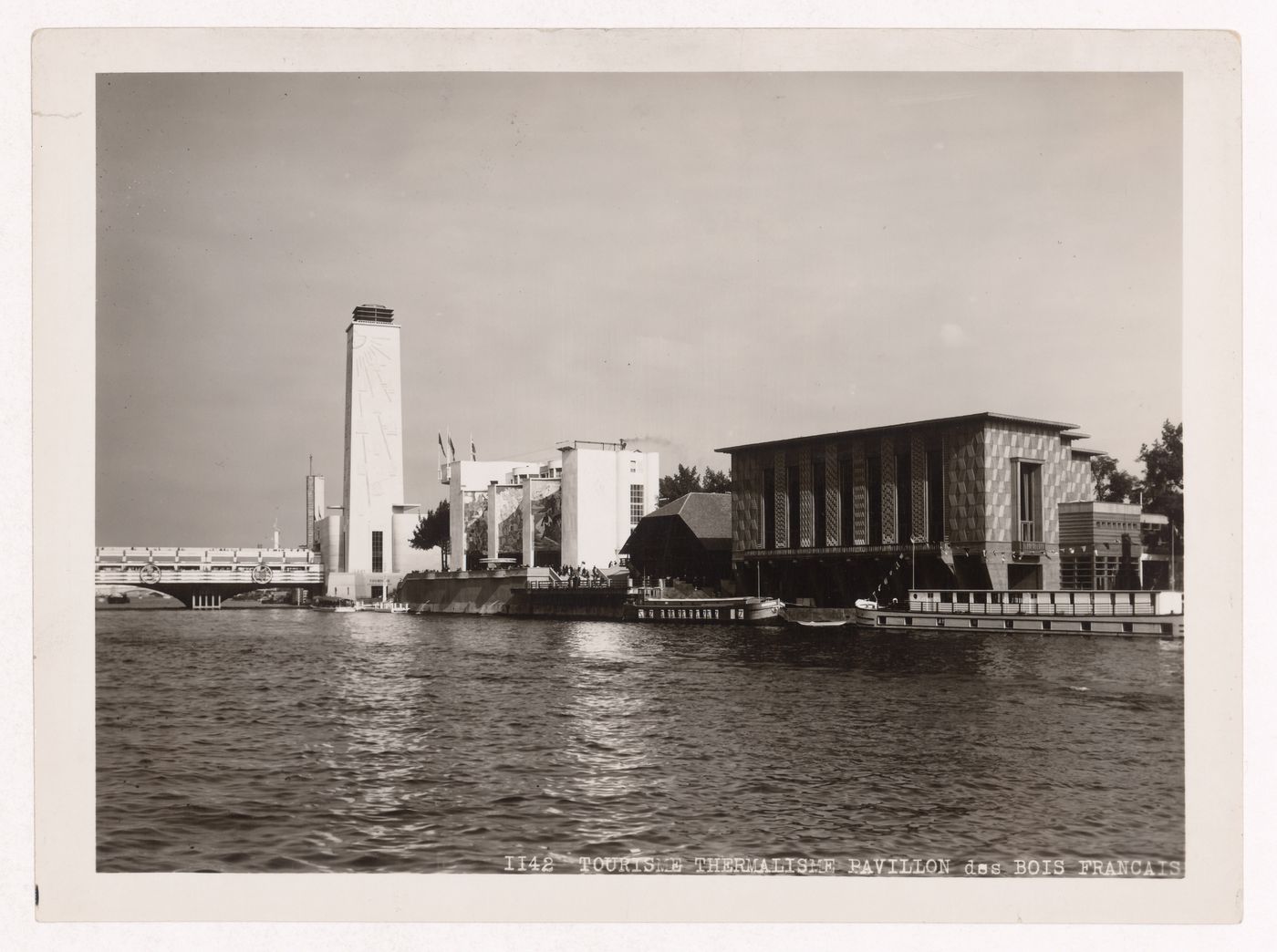 View of the Pavillon du Tourisme, the Pavillon du Thermalisme and the Pavillon du Bois fançais with the Passerelle de l'Alma in the left background and the Seine in the foreground, 1937 Exposition internationale, Paris, France