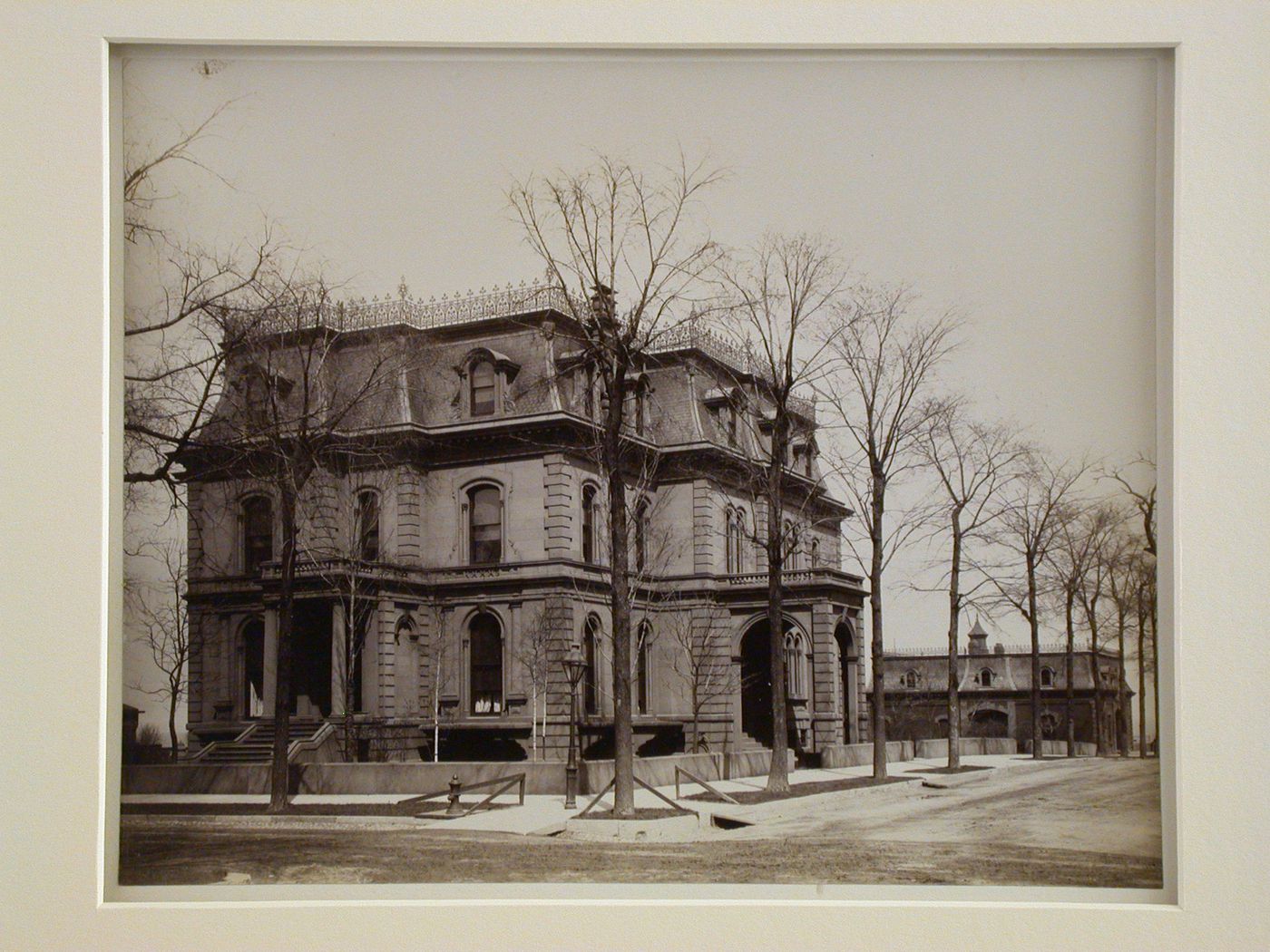 Three-quarter exterior view of Victorian stone building at intersection of tree-lined streets, Pullman, Illinois