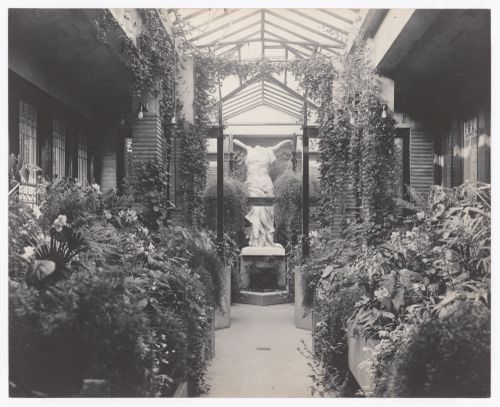 Interior view of Darwin D. Martin House showing the conservatory with plants and a statue of Nike, Buffalo, New York