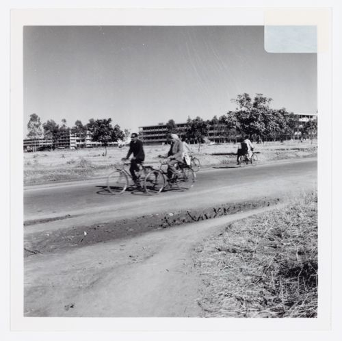 Two men on bicycles in front of the Main Commercial Centre, Sector 17, in Chandigarh, India