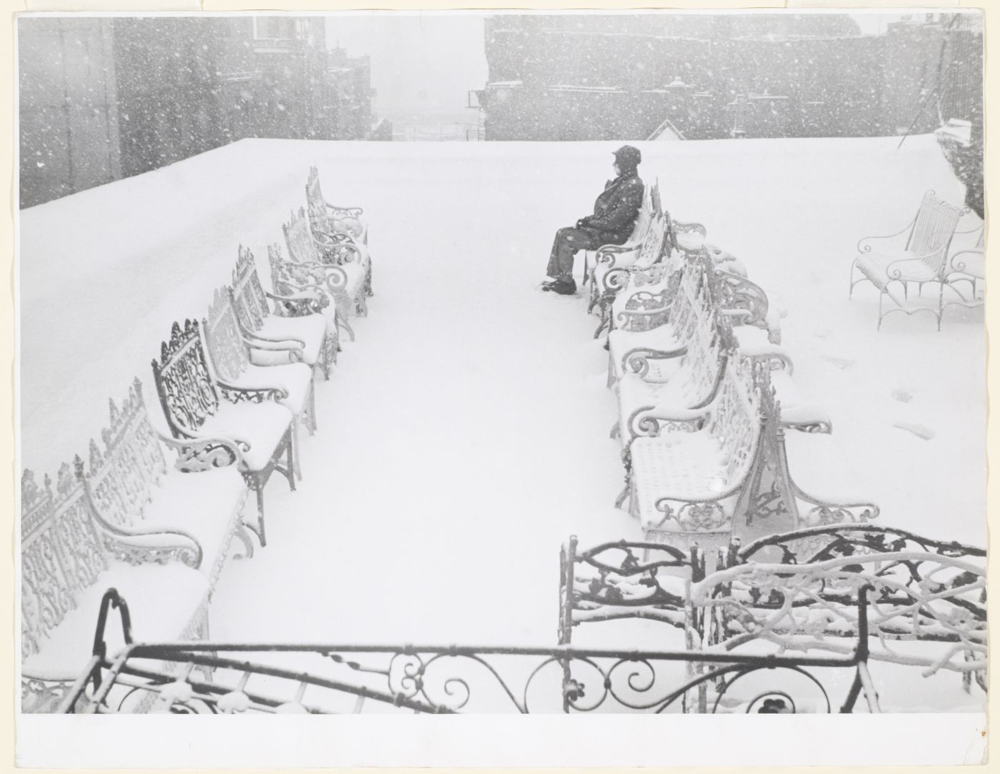 Man seated on bench in snow on rooftop of old Newell Art Galleries, New York City, New York