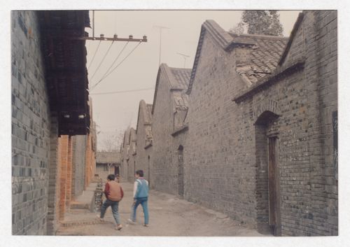 View of a street with houses and two passersby possibly related to Sichuan housing project in China