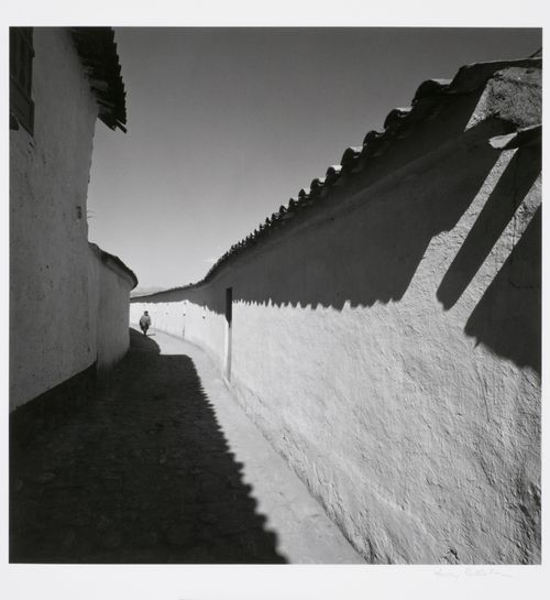 View of a woman walking along an alley, Cuzco, Peru