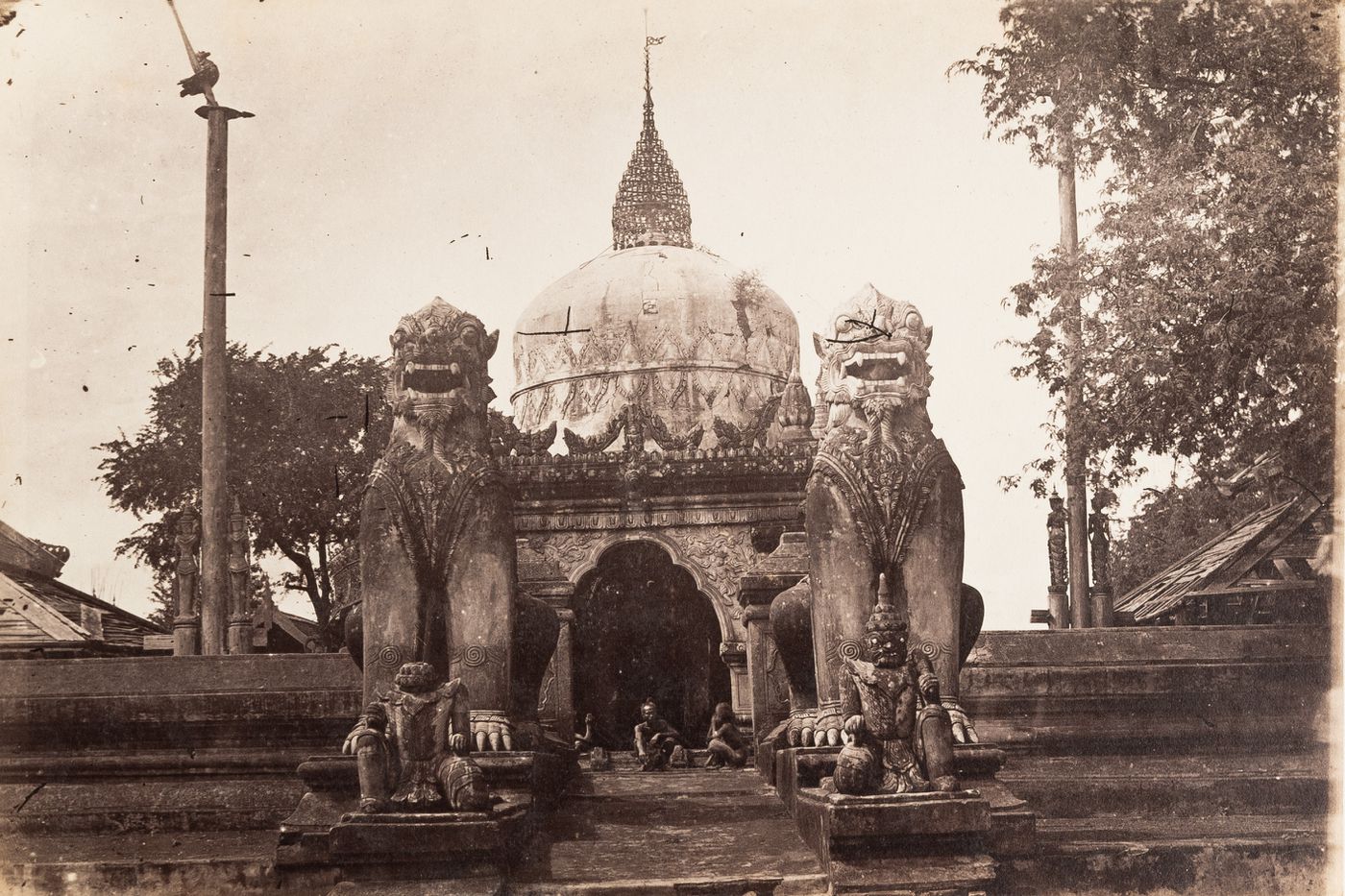 View of a pagoda flanked by two seated dragons, near Mandalay, Burma (now Myanmar)