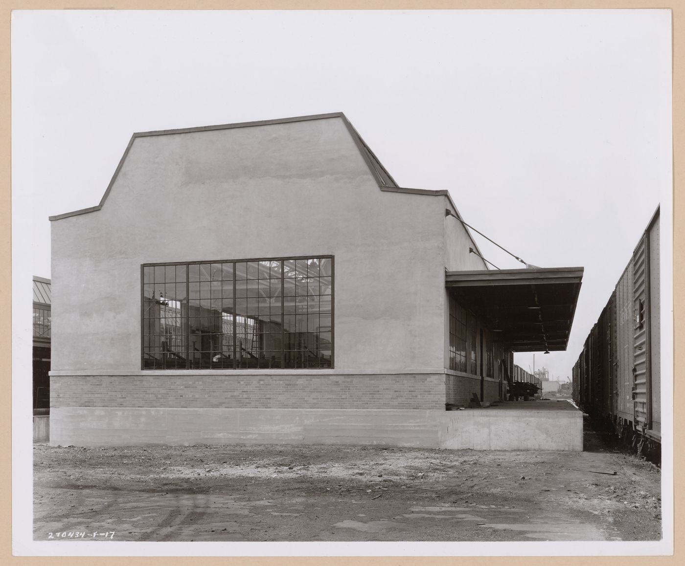 View of the principal and lateral façades of the Paint Mixing and Storage Building with the loading dock and a train on the right, General Motors Corporation Chevrolet division Commercial Body Plant, Indianapolis, Indiana