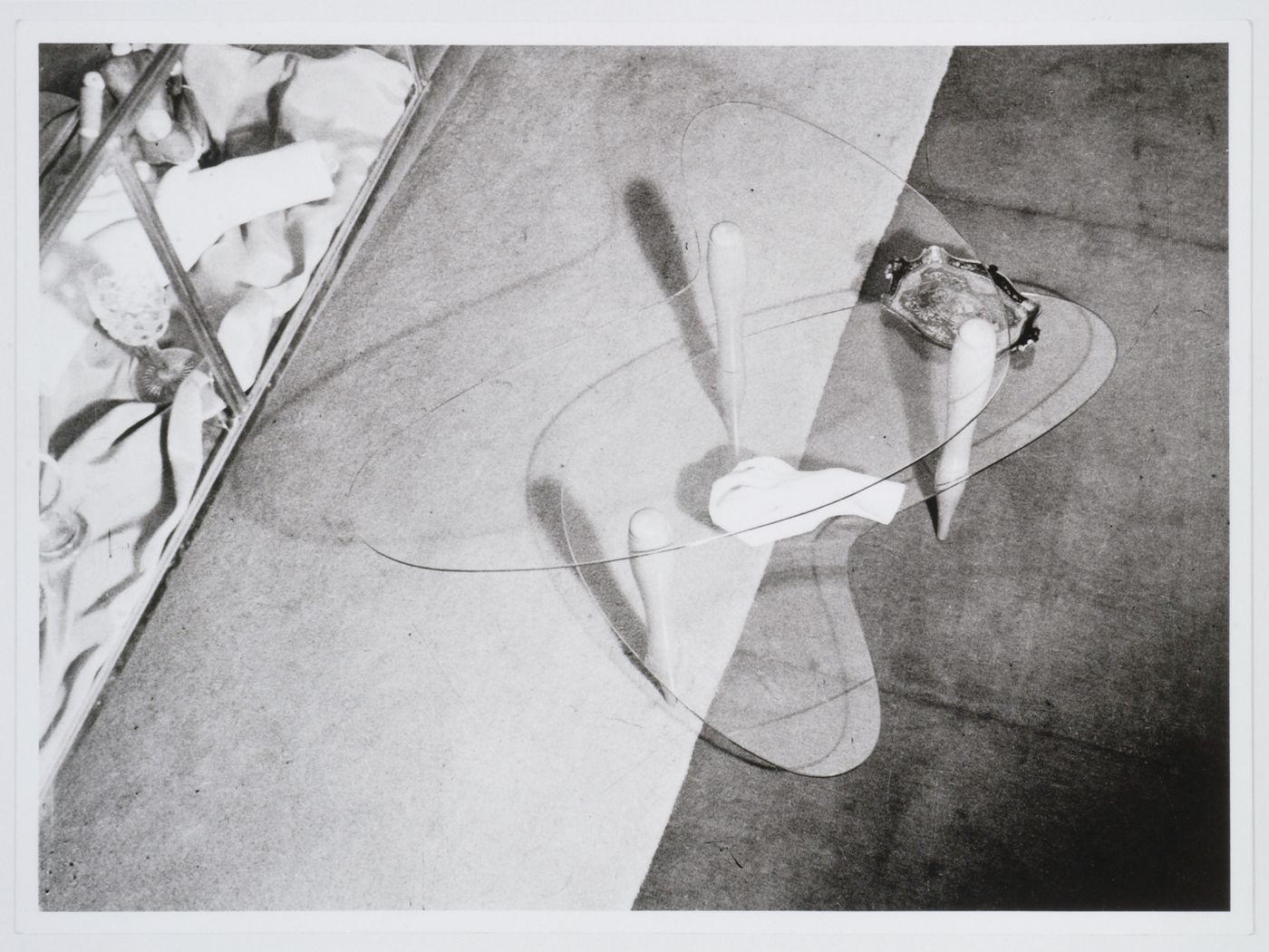Interior view of Casa Miller showing a table, designed by Carlo Mollino, with three legs of turned wood and shelves of  Securit glass, Turin, Italy