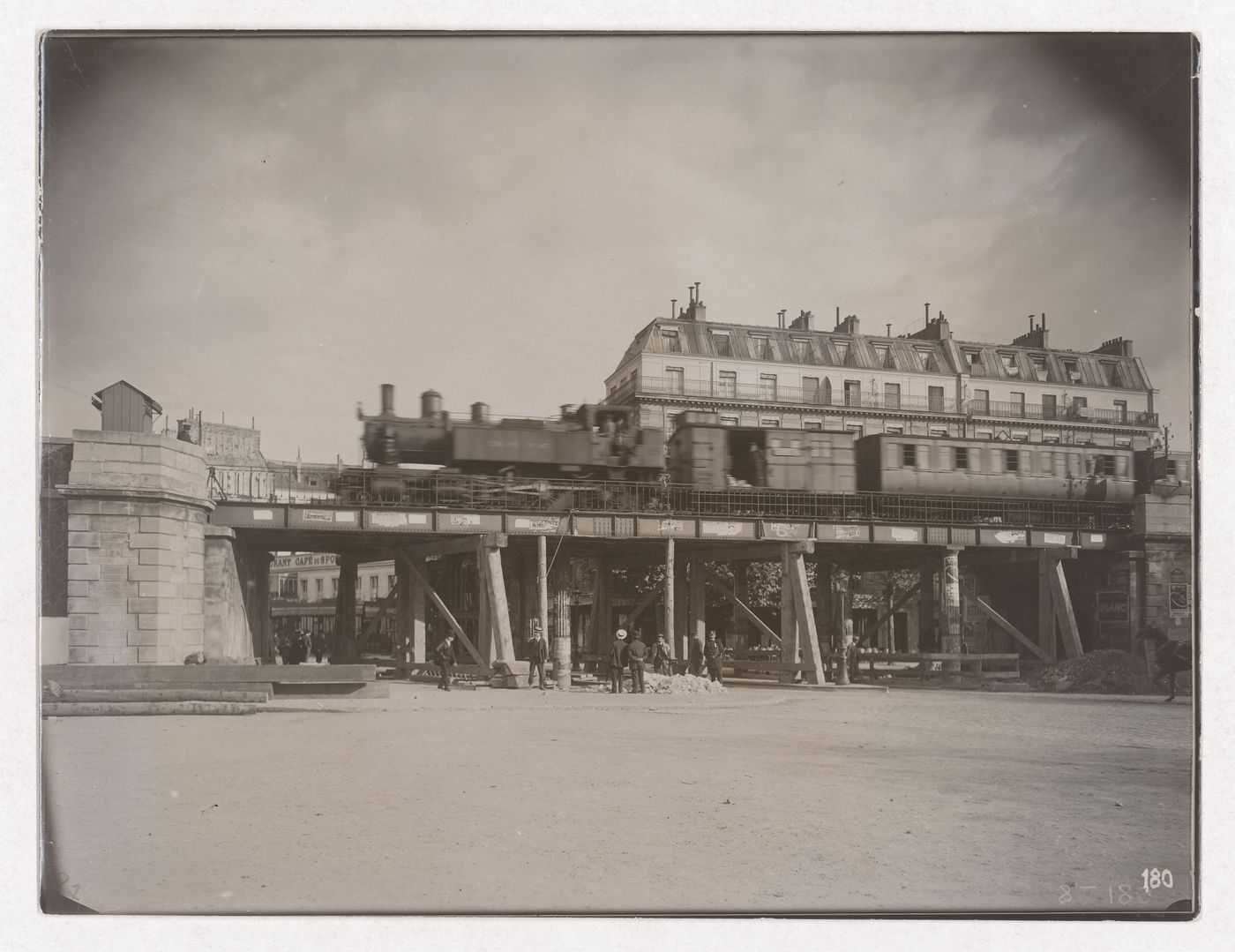 Construction of the Paris Metro, exterior view with train on raised bridge with men standing under the bridge, Paris, France