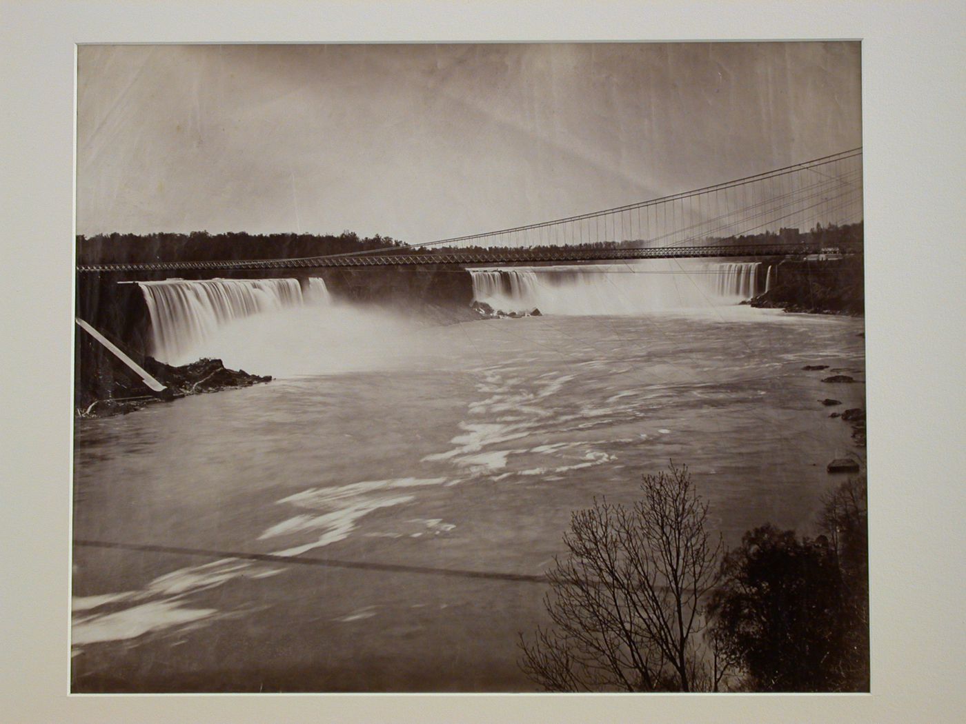 View with part of suspension bridge in foreground, Niagara and Horseshoe Falls, New York
