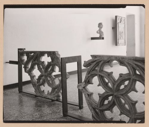 Interior view of a gallery showing fragments of stone tracery with a bust and reliefs in the background, Museo Correr, Venice, Italy