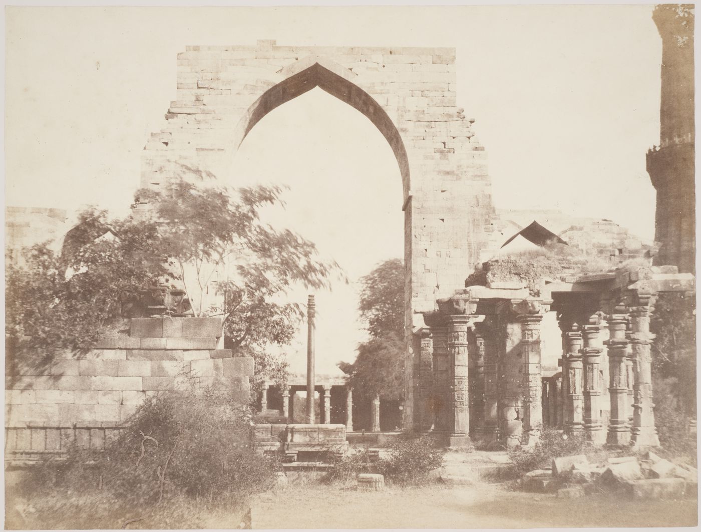 View of the courtyard of the Quwwat al-Islam [Might of Islam] Mosque  showing the Iron Pillar with the Qutb Minar on the far right, Quwwat al-Islam Mosque Complex, Delhi, India
