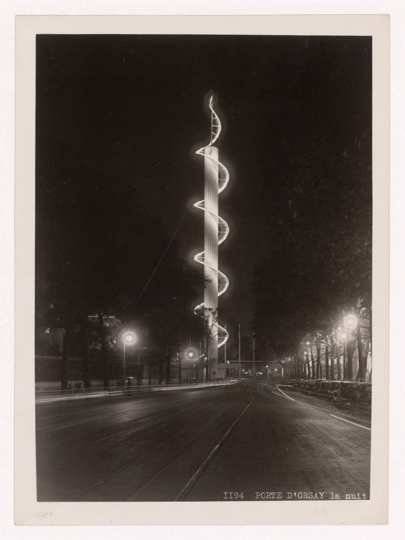 Night view of an illuminated column with the Porte D'Orsay or Porte Constantine in the background, 1937 Exposition internationale, Paris, France