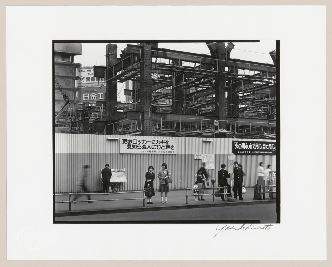 View of pedestrians, metal hoarding and a building under construction, Tokyo, Japan