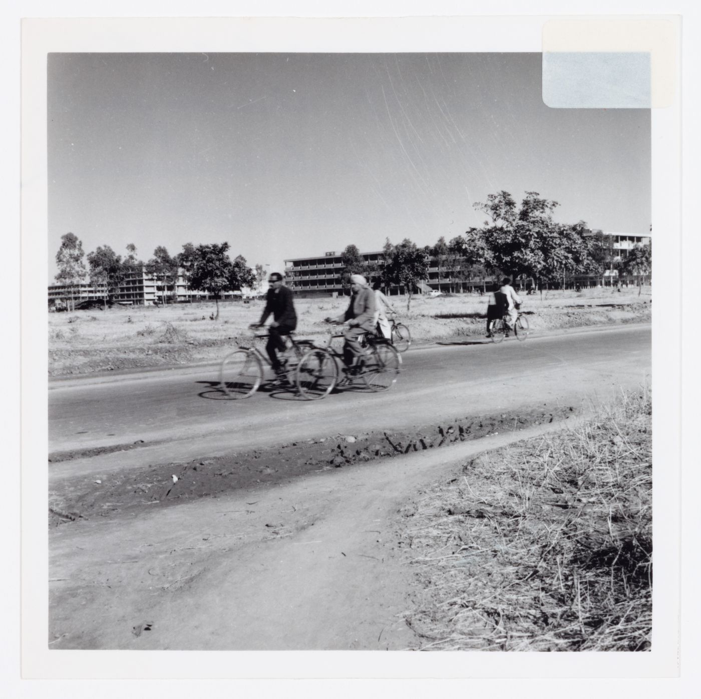 Two men on bicycles in front of the Main Commercial Centre, Sector 17, in Chandigarh, India