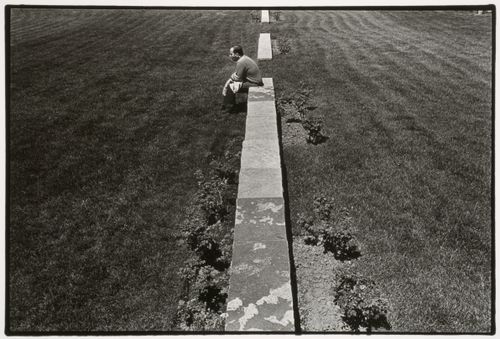 View of a man sitting on one of the cadastral walls which represent rural "rangs" or property lines, CCA garden, Montréal, Québec, Canada