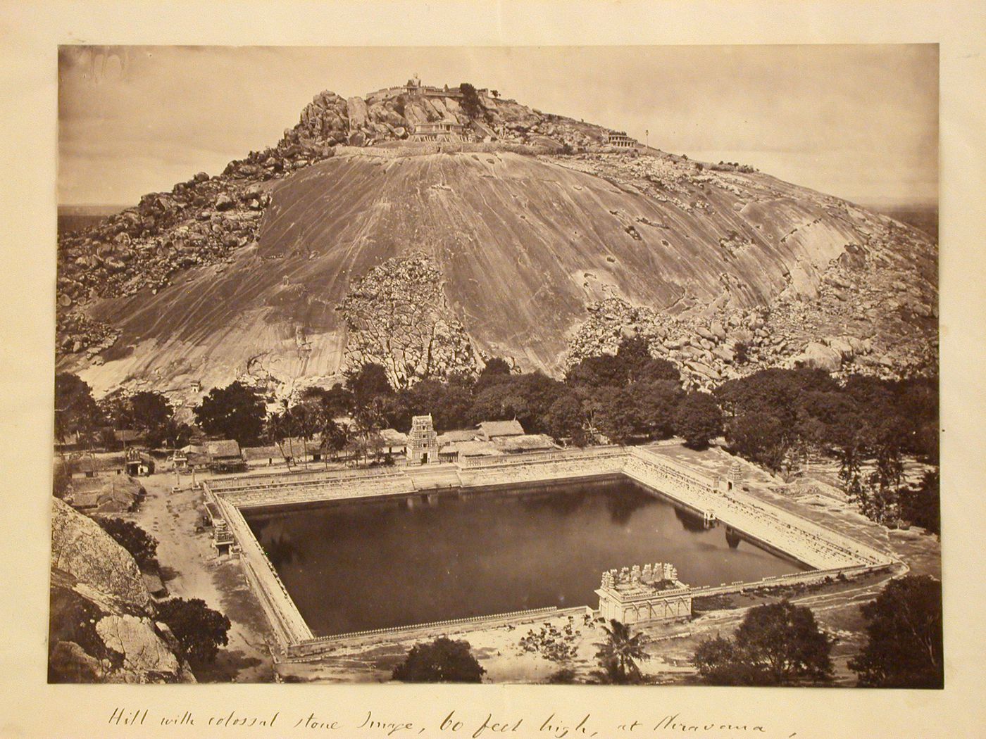 View of Vindhyagiri with the Odegal Basti, Brahmadeva Mandapa, Channanna Basti, Siddhara Basti and Gommateshvara Image on the summit and a water tank and buildings at the base, Shravana Belgola (now Sravana Belgola), India