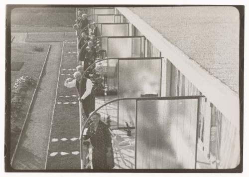 Exterior view of Budge Foundation Old People's Home showing residents standing on the second-floor balconies, Frankfurt am Main, Germany