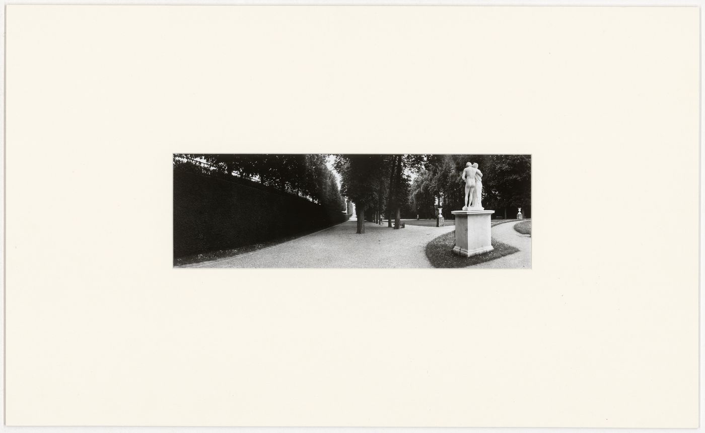 View of an allée of Parc de Saint-Cloud bordered by hedges and trees with a statue and urns on the right, France