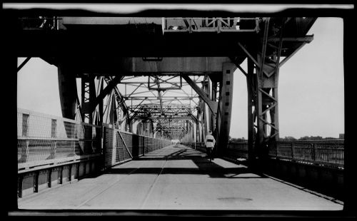 View of man riding a bicycle on the Blue Nile Road and Railway Bridge, Khartoum, Sudan