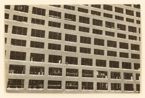 View of industrial building with workers outside windows on platforms, Manhattan, New York, United States
