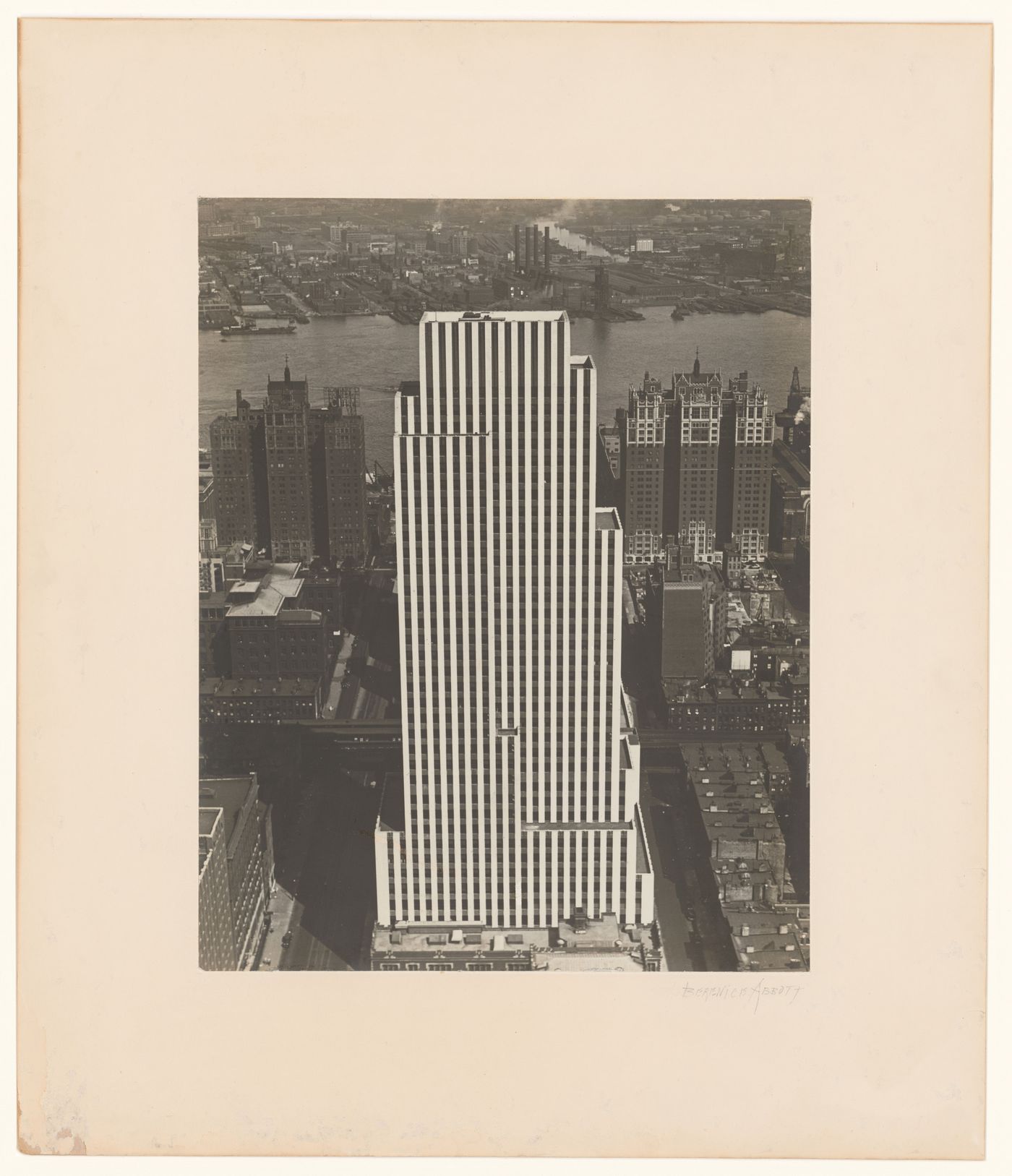 View of the Daily News Building, looking down with surrounding structures and East River, New York City, New York