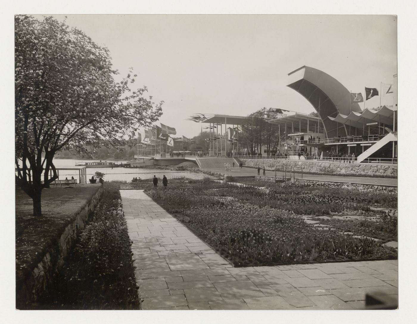 Exterior view of the Entrance Pavilion and hall 2 at the Stockholm Exhibition of 1930 showing a garden and walkway, Stockholm