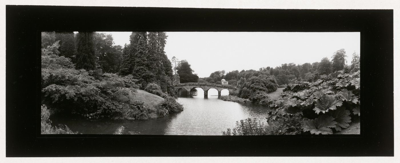 View of a park or garden showing a bridge and a garden house in the Greek style in the background