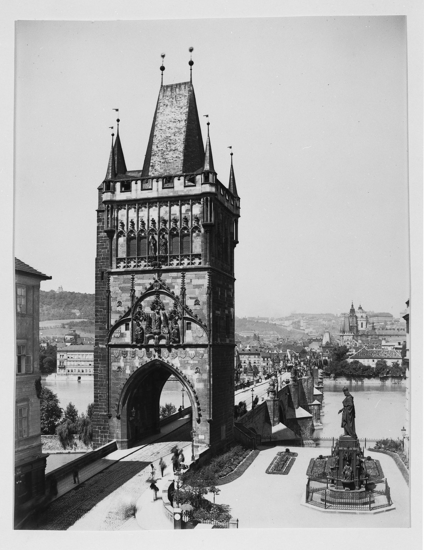View of tower and bridge, looking across the river, with statue in foreground, Prague, Czeckoslovakia