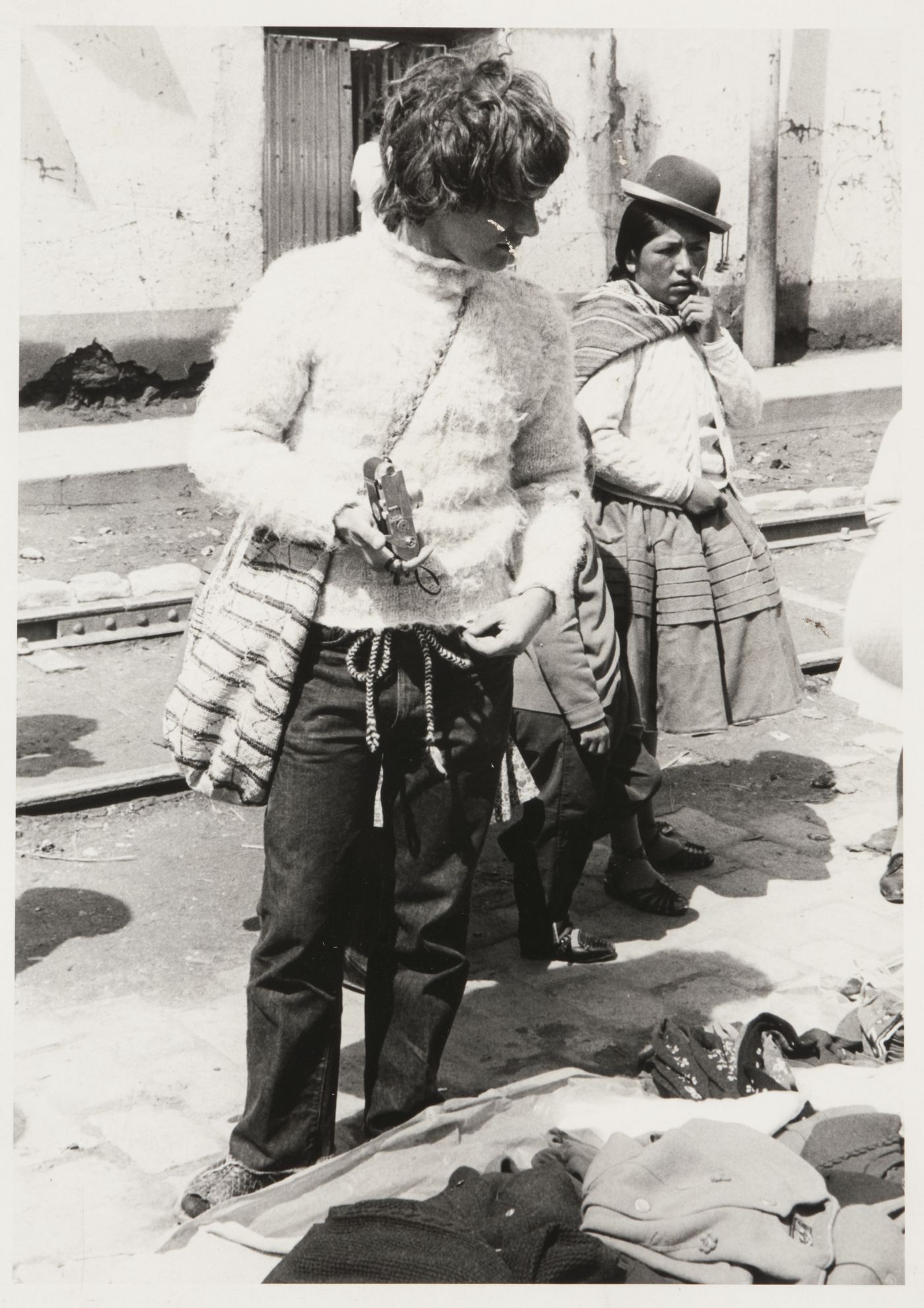 Gordon Matta-Clark holding a camera in a market, probably Peru