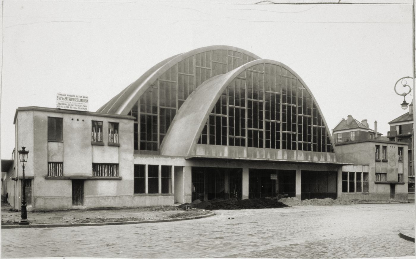 View of the 'halle centrale' (main hall) building, showing the arched structure and glass walls, Établissements Limousin & Cie, Reims, France