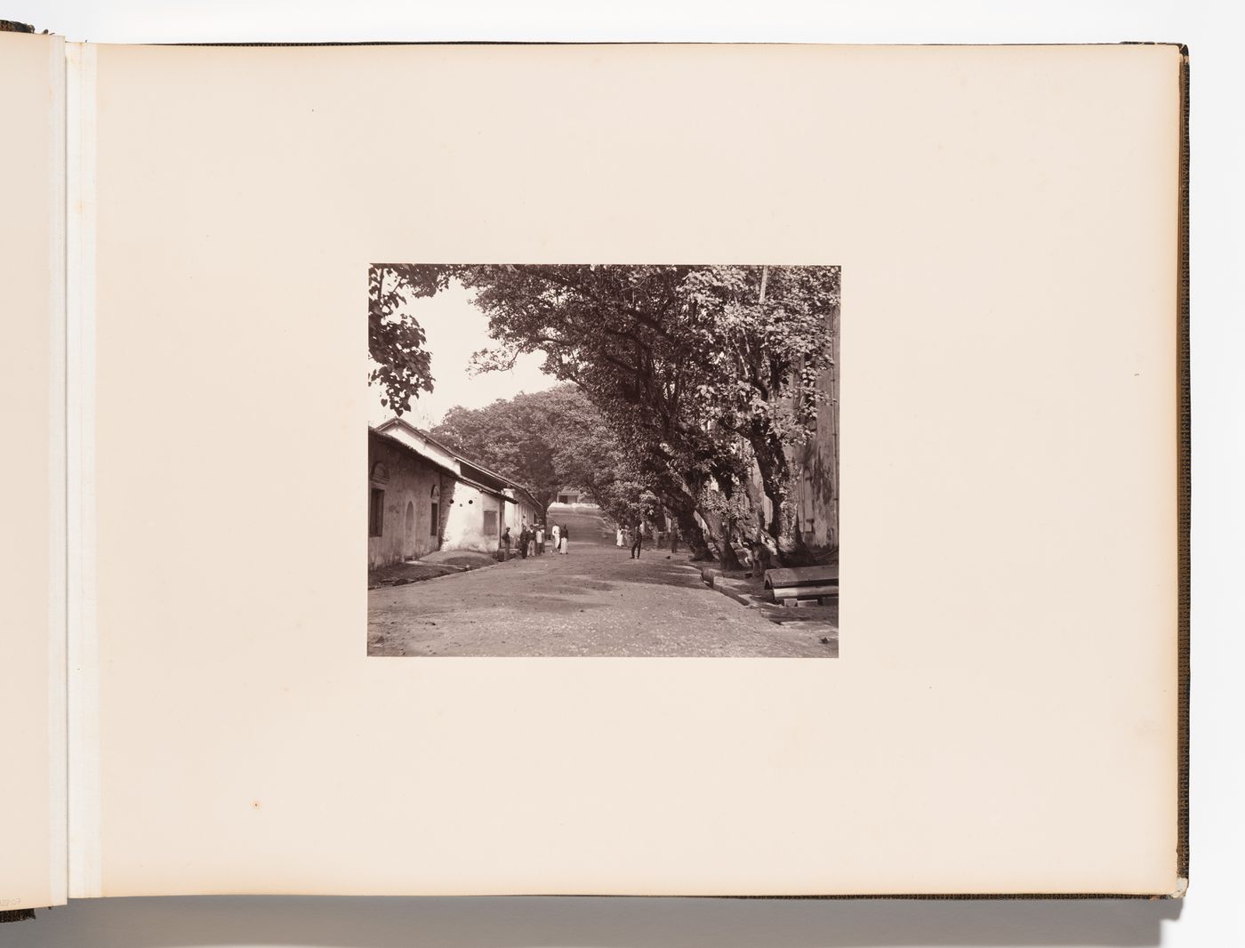 View of a street showing unidentified buildings with a church tower in the left background, Point de Galle (now Galle), Ceylon (now Sri Lanka)
