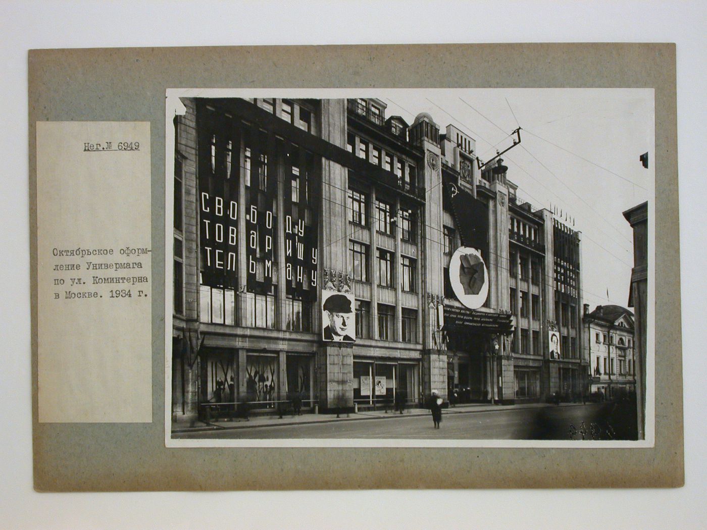 View of the principal façade of a department store showing applied decorations, including two portraits of unidentified men, in celebration of the 17th anniversary of the Bolshevik Revolution, Kominterna Street, Moscow, Soviet Union (now in Russia)
